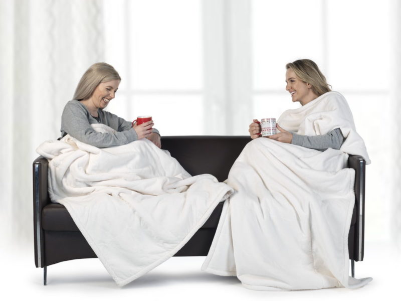 women sitting on a couch with a couple of cups