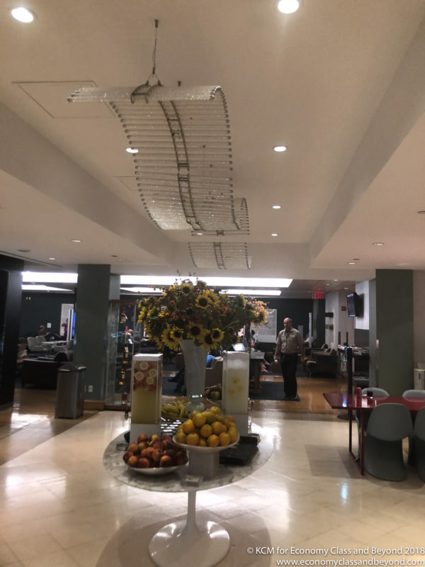 a vase of flowers and fruits in a lobby