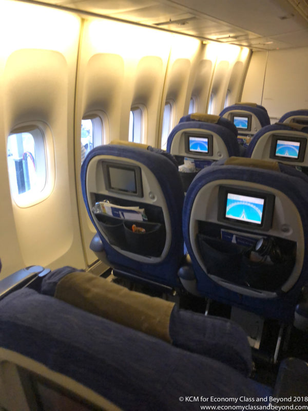 seats in an airplane with a screen on the back