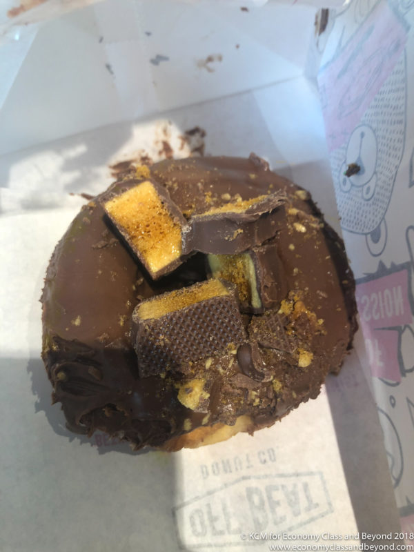 a chocolate covered donut with a bite taken out of it