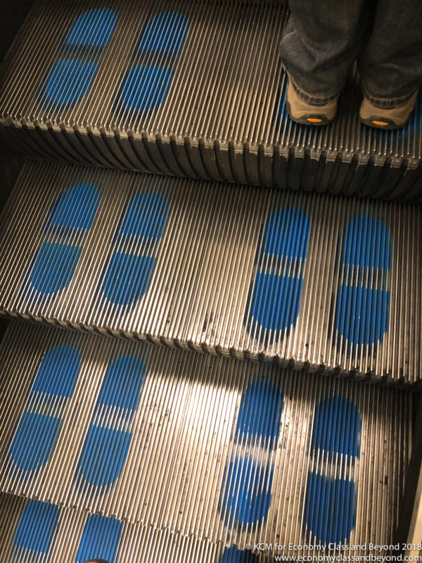 a person's feet on a set of escalators