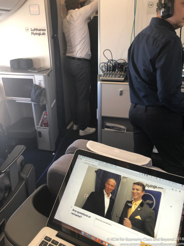 a man standing in an airplane with a laptop