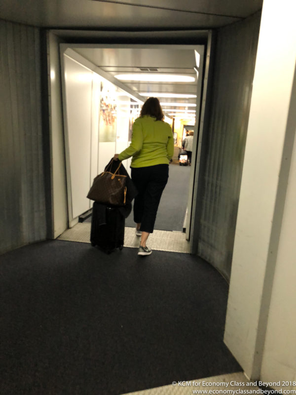 a woman in a green shirt pulling luggage