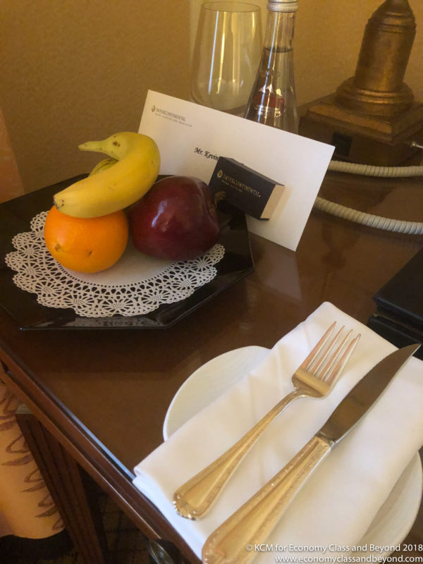 a plate with fruit on it and a fork and knife on a table