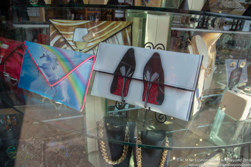 a group of purses on a glass shelf