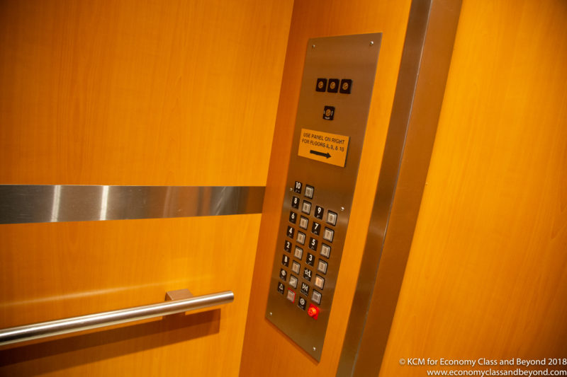 a elevator panel with buttons and a metal bar