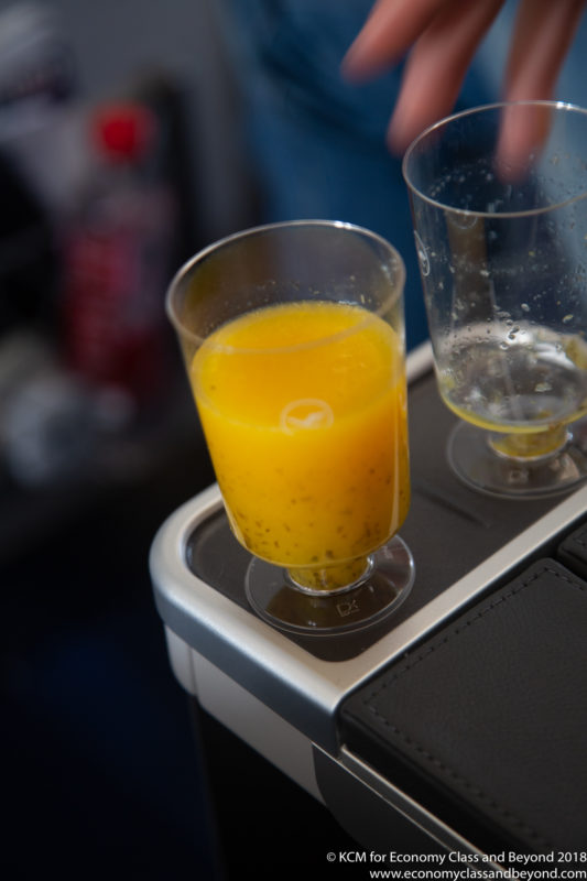 a glass of orange juice on a black surface