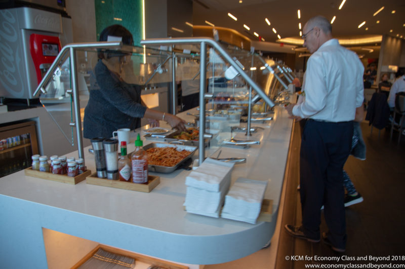 a man and woman standing at a buffet