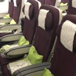 a row of seats with green pillows