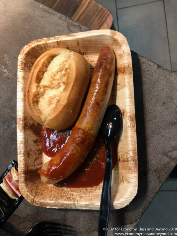 a plate of food with a black spoon and a sausage