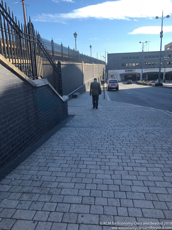 a man walking down a brick walkway
