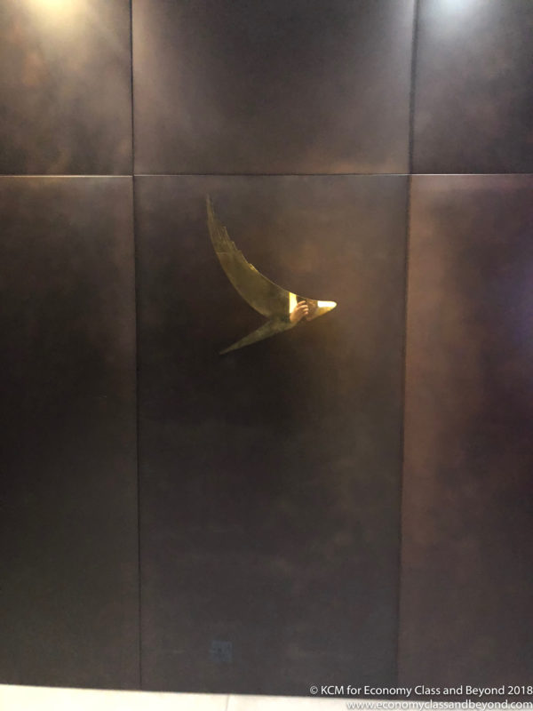 a metal wall with a bird's head