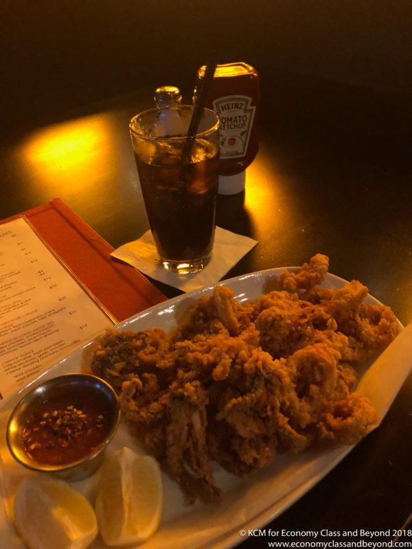 a plate of fried food and a drink on a table