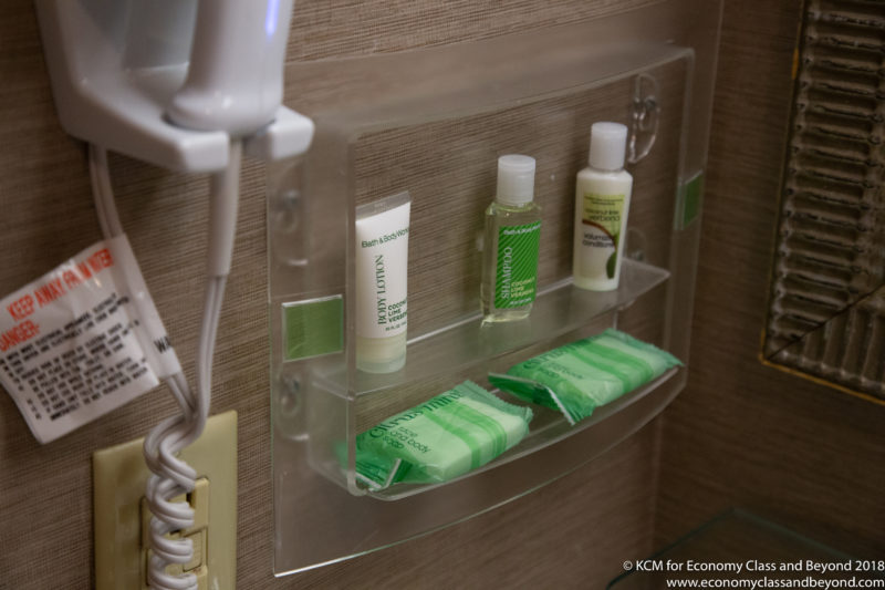 a shelf with small bottles of shampoo and other items on it