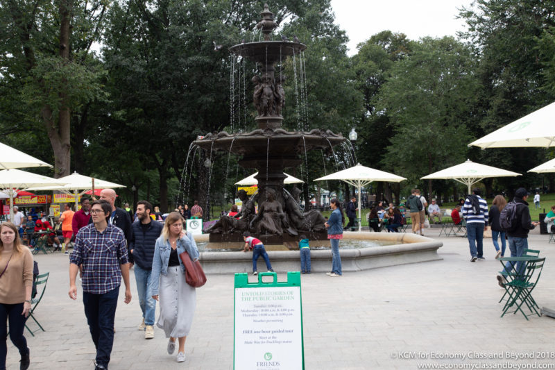 a group of people walking around a fountain
