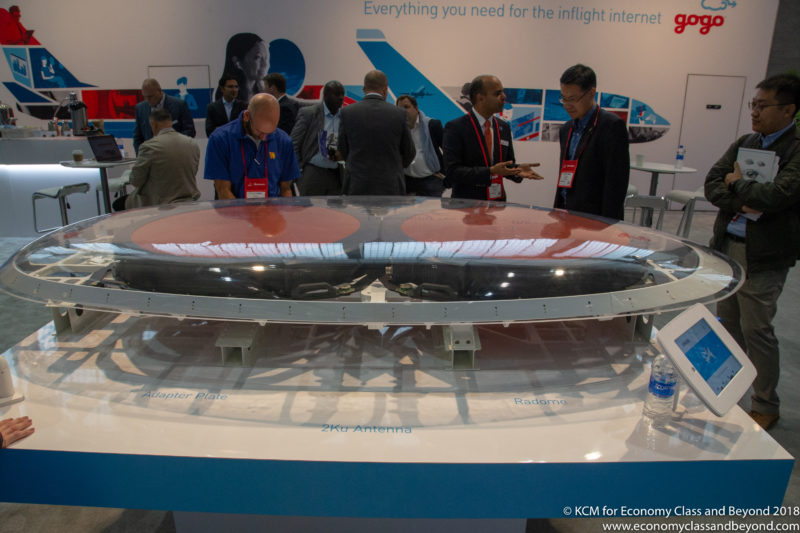 people standing around a table with a model of a plane