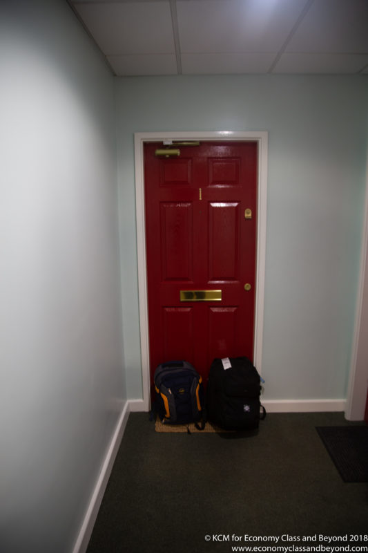 a red door with two backpacks in front of it