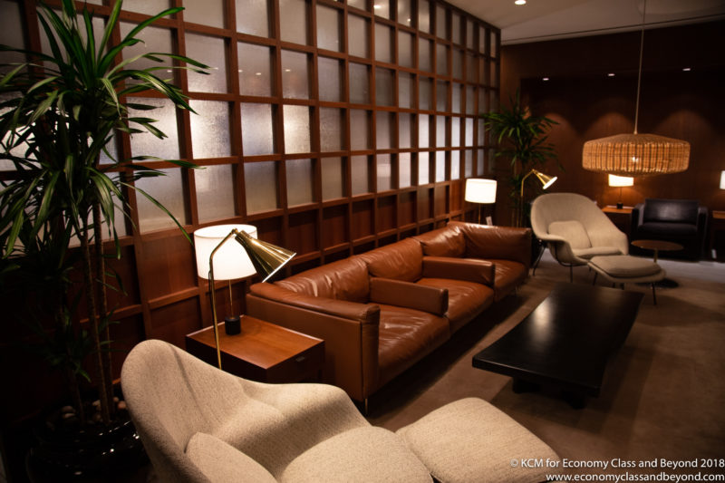 a room with a brown couch and chairs