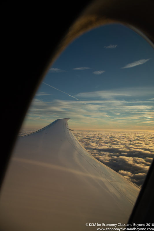 a wing of an airplane above the clouds