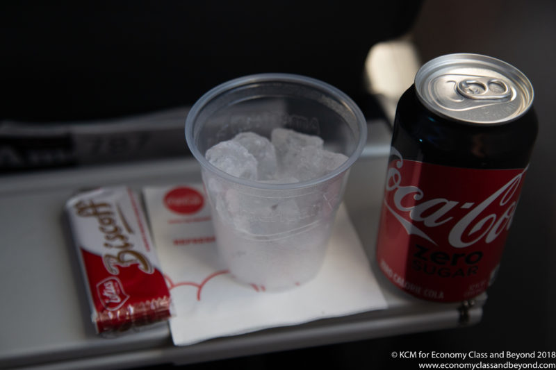 a soda can and a cup of ice on a tray