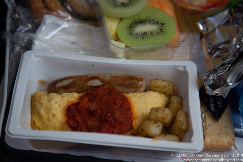 a tray of food with a sausage and potatoes