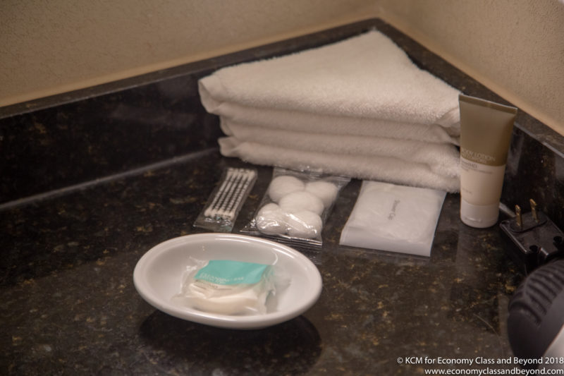 a white towel and a dish with a soap and cotton swabs