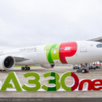 a large white airplane with green and red writing