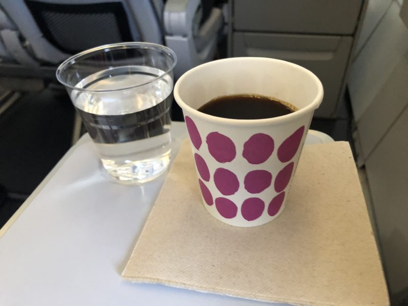 a cup of coffee and a glass of water on a tray