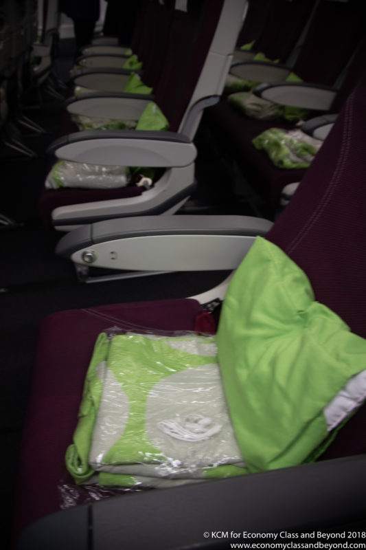 a row of seats with green pillows