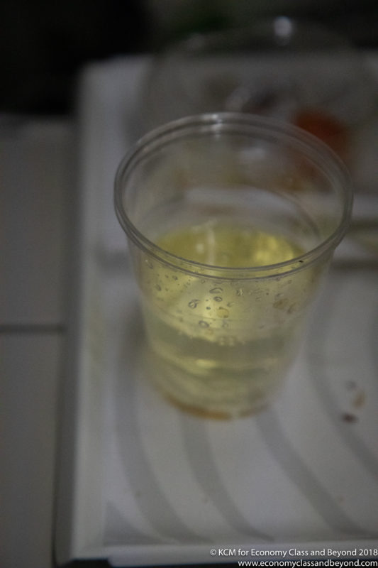 a clear plastic cup with yellow liquid in it