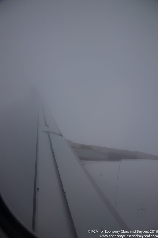 the wing of an airplane in the fog
