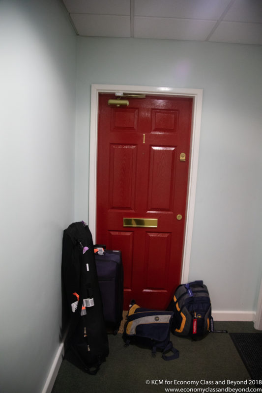 a red door with luggage on the floor