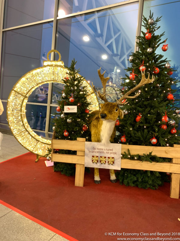 a reindeer statue next to a christmas tree
