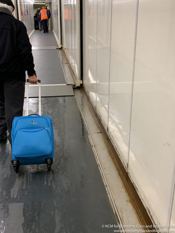 a person pulling a blue suitcase