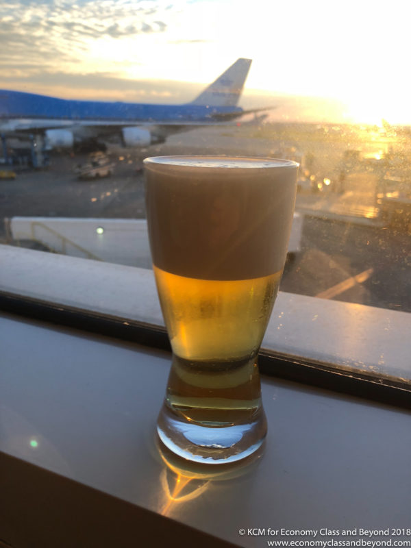 a glass of beer in front of an airplane