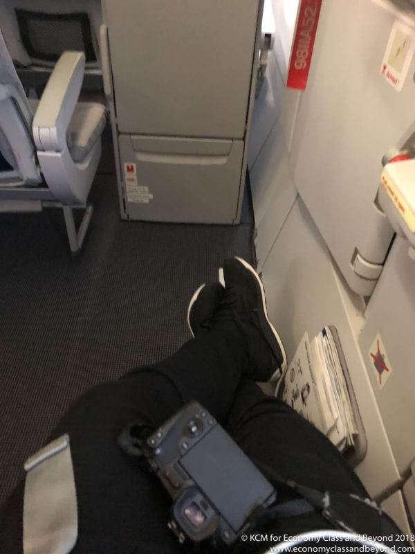 a person's legs and feet on an airplane