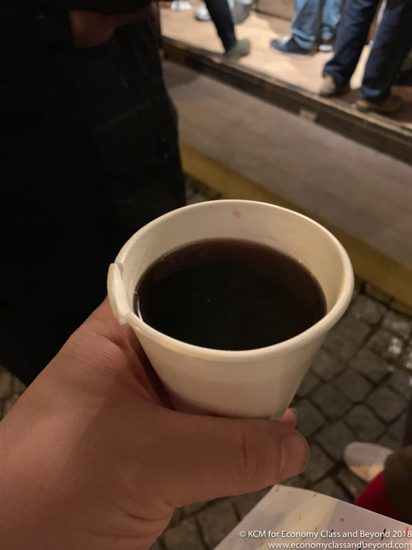 a hand holding a cup of liquid