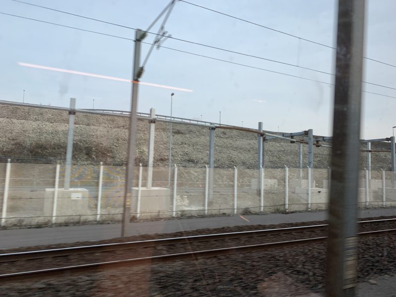 a train tracks next to a fence