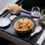 a bowl of soup and wine on a tray