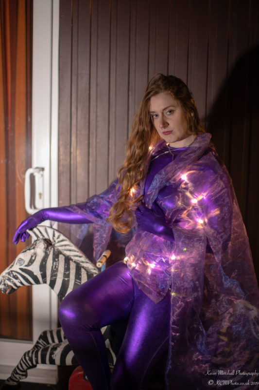 a woman in purple outfit with lights on a zebra