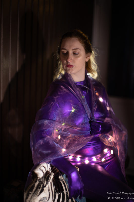 a woman in a purple leotard with lights