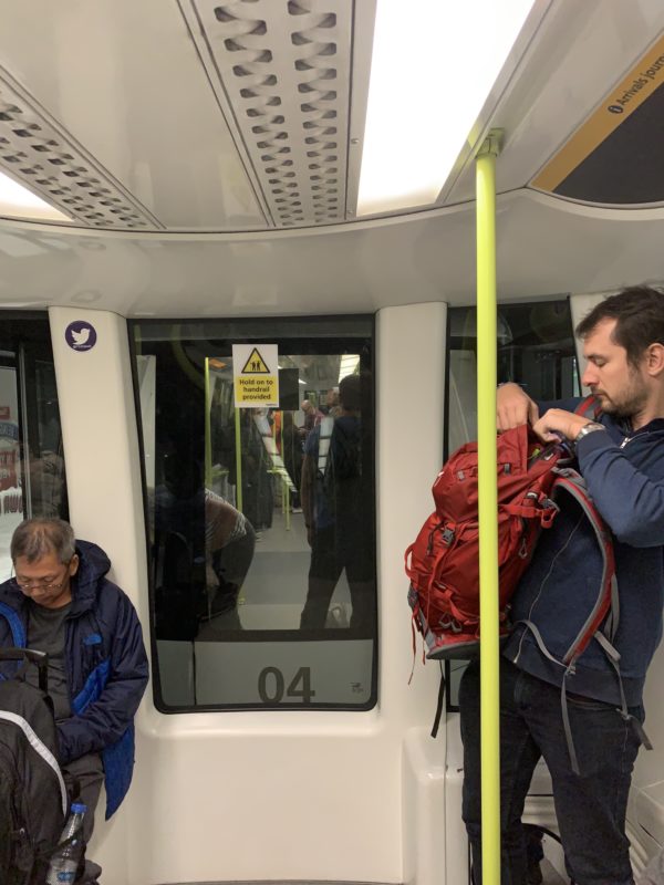 a man standing on a train with a backpack