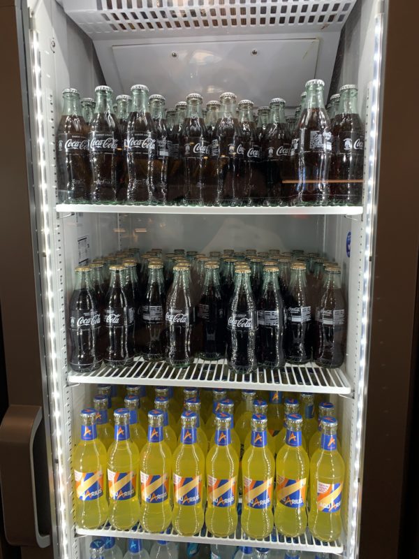 a shelf of soda bottles