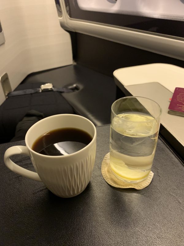 a cup of coffee and a glass of water on a table
