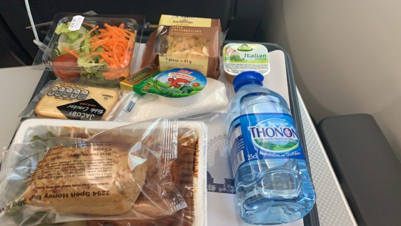 food on a tray with a bottle of water