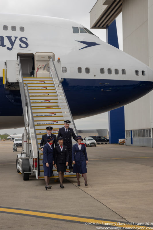 a group of people in uniform walking up stairs of an airplane