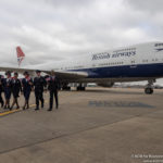 a group of people walking next to a large airplane