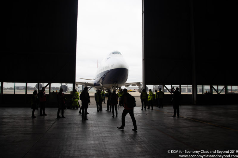 a group of people standing in a hangar with a large airplane