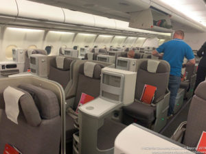 a man standing in a row of seats on an airplane