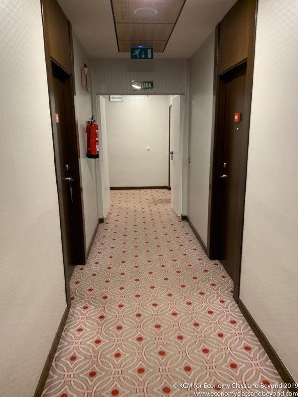 a hallway with doors and a fire extinguisher